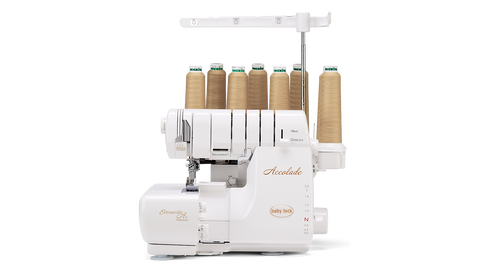 A white Baby Lock Accolade serger with eight spools of tan thread.