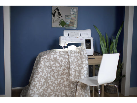 Baby Lock Allegro sewing and quilting machine on a table with a floral fabric.