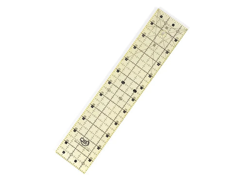 A clear, rectangular quilting ruler with black grid lines and numbers, angled on a white background.