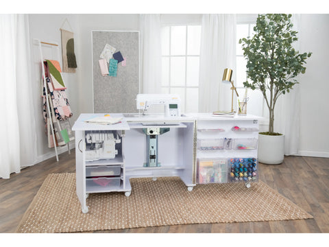 A white sewing cabinet with a sewing machine, storage, and a serger.