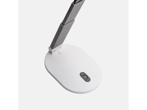 A white and grey foldable table lamp with a control panel on its base.