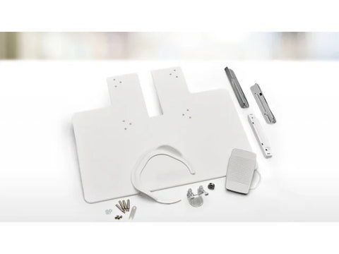 A white free-motion quilting extension table with various accessories.