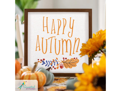 A framed sign with "HAPPY AUTUMN" in orange text and fall foliage.