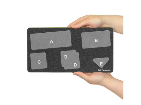 A person holds a black AccuQuilt GO! die with five labeled cutting shapes.