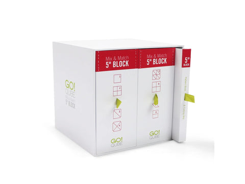 A white AccuQuilt Qube Mix & Match 5" Block set with red and green accents.