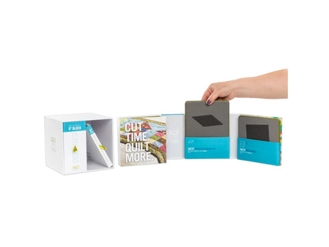 A person's hand places a cutting die into the AccuQuilt Qube Mix & Match 6" Block set.