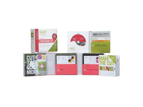 A collection of AccuQuilt Qube Companion Corners 8" quilting tools and pattern books.