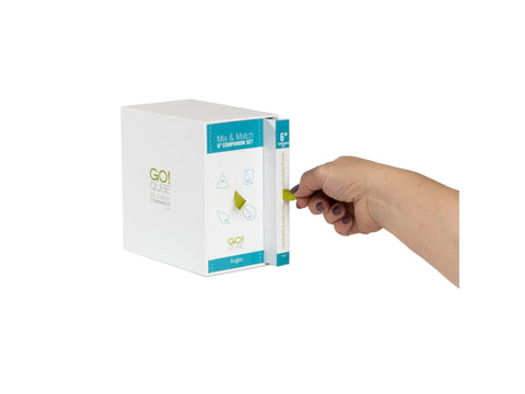 A hand pulls a green tab from a white box labeled "GO! QUBE Mix & Match 6" Companion Set Angles".
