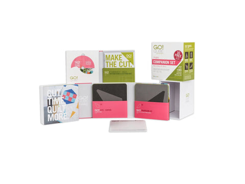 A collection of AccuQuilt GO! Qube quilting products, including die sets and pattern books.