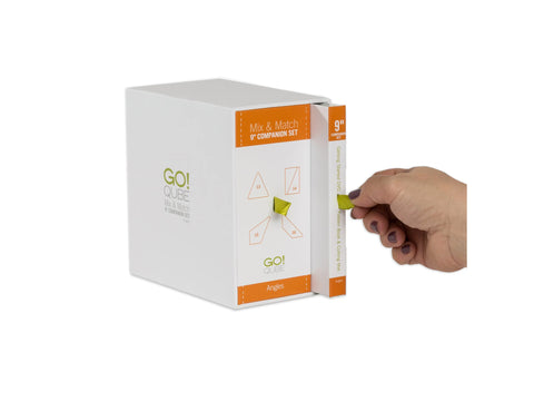 A white box with orange accents, labeled "GO! QUBE Mix & Match 9" Companion Set Angles," with a hand pulling out a book.