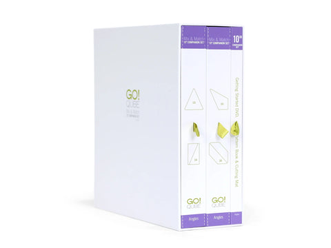 A white box set with purple accents contains three books and a DVD for AccuQuilt Qube.