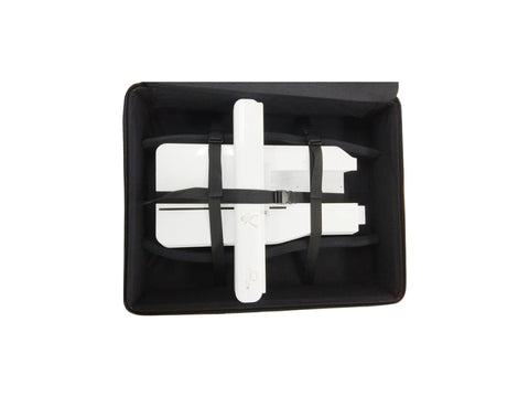 A white embroidery machine unit is secured in an open black project bag.