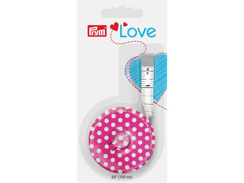 A pink polka dot Prym Love magnetic tape measure with a blue heart design.