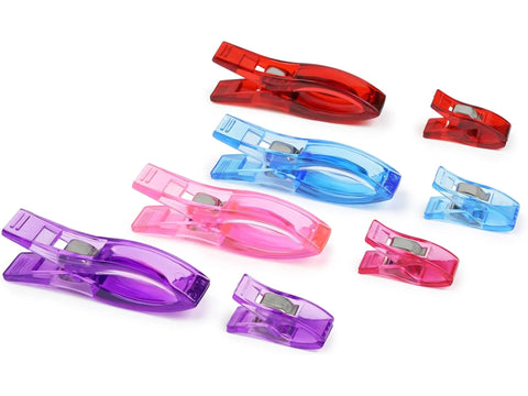 Assorted small and large fabric clips in red, blue, pink, and purple.
