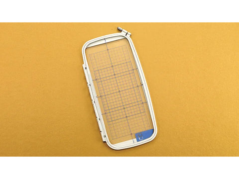 An embroidery hoop with a grid, measuring 5 by 12 inches, on a gold background.