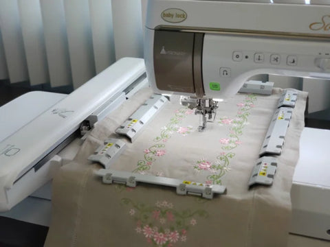 Baby Lock Solaris embroidery machine with a magnetic frame stitching a floral design.
