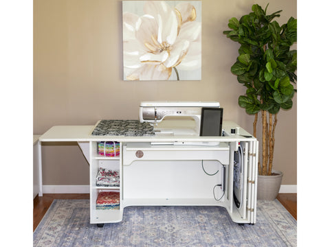 A white sewing and embroidery cabinet with a bifold front door and hoop storage.