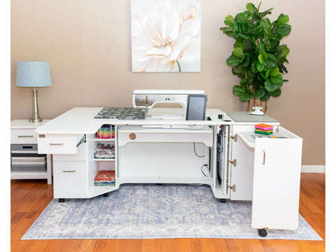A white sewing, embroidery, and serger cabinet with a front drawer extension.