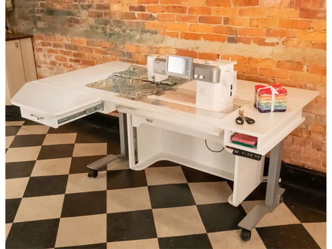 A white Horn Model 9100 height-adjustable sewing table with a sewing machine and fabric.