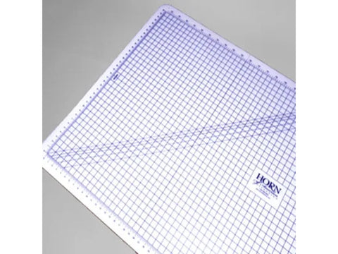 A white cutting mat with a purple grid pattern and rulers along the edges.