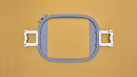 A gray Baby Lock Alliance Flat Frame is centered on a golden background.