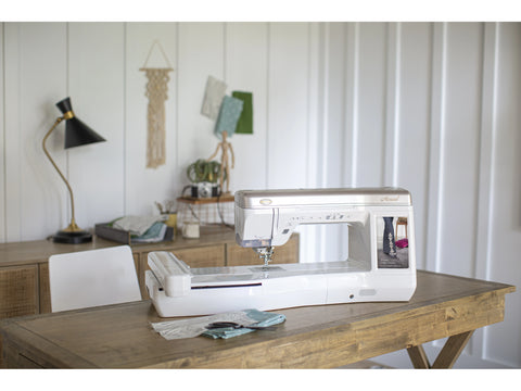 A Baby Lock Aerial sewing and embroidery machine sits on a wooden table.