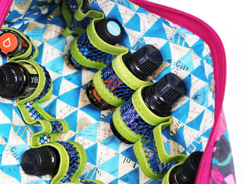 An open fabric bag with blue and white geometric patterns holds several small bottles.