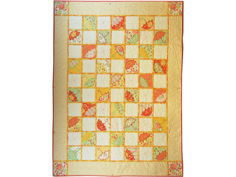 A quilt featuring embroidered umbrella blocks in various colors and patterns.