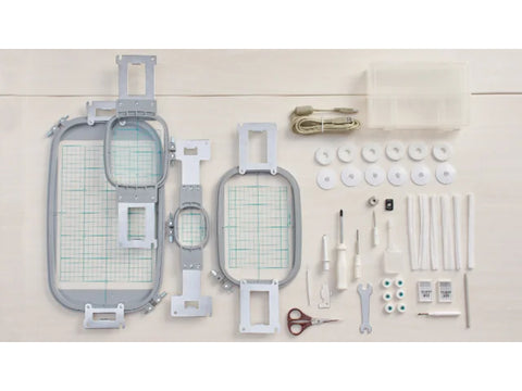 A collection of embroidery hoops, tools, and accessories for a sewing machine.