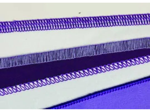 Close-up of various purple serged stitches on white and purple fabric.