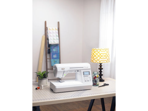 Baby Lock Presto II sewing and quilting machine on a table with sewing supplies.