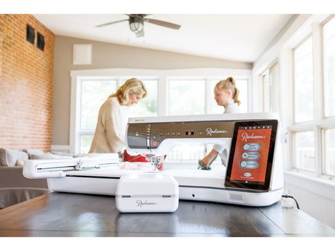 A white Baby Lock Radiance sewing and embroidery machine sits on a wooden table.