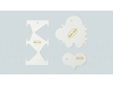 A set of three white quilting rulers with "baby lock" printed on them.