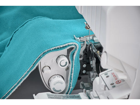 A Baby Lock Victory serger is shown with teal fabric being sewn.