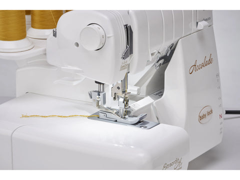 A white Baby Lock Accolade 8-thread serger with yellow thread spools.