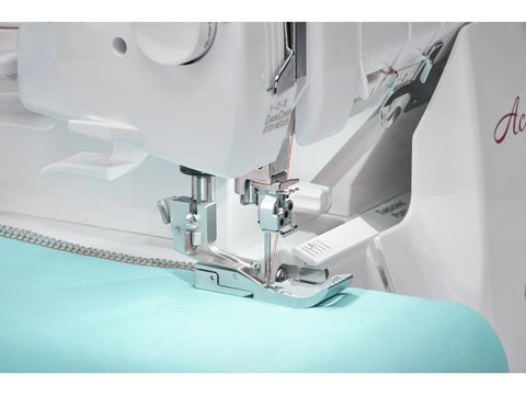 A white Baby Lock Accolade serger machine with light blue fabric under the presser foot.