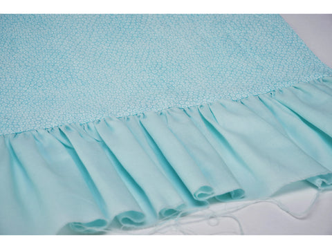 Light blue fabric with a white dotted pattern and a ruffled bottom edge.