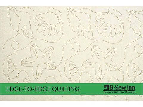 A cream fabric is quilted with a repeating pattern of seashells, starfish, and swirling lines.