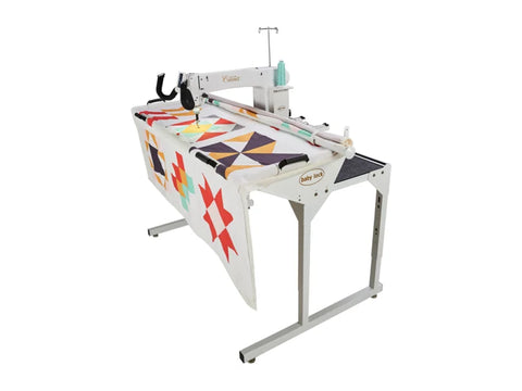 A Baby Lock Coronet longarm quilting machine with a 5ft frame and a colorful quilt.