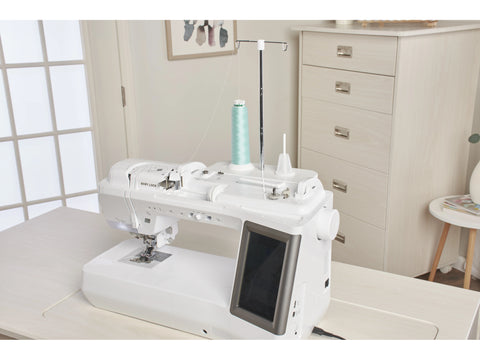 A white Baby Lock Ballad sewing and quilting machine with a light blue spool of thread.
