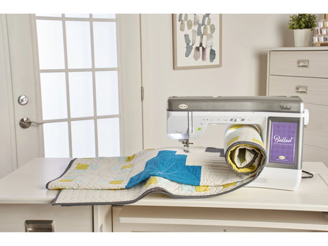 A Baby Lock Ballad sewing and quilting machine with a quilt on its extension table.