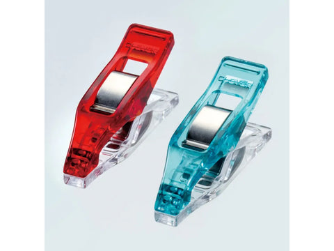 Twenty small, translucent sewing clips, ten red and ten blue, are arranged on a white surface.