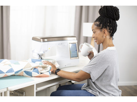 A woman smiles while using a Baby Lock Chorus sewing and quilting machine.