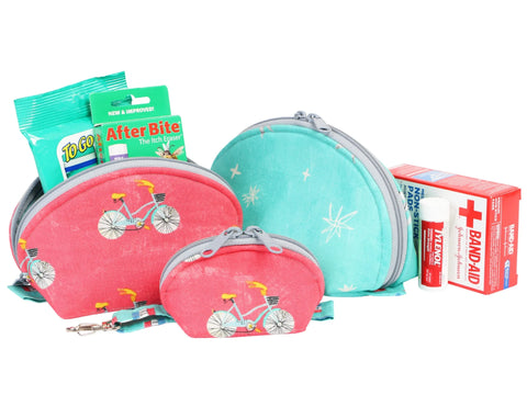 Five zippered clam-shaped bags in various sizes, with two featuring a bicycle print and one a star print, accompanied by first aid supplies.