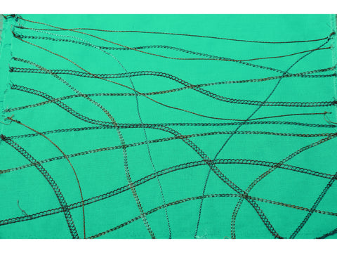 A piece of teal fabric with various black and brown thread stitches.