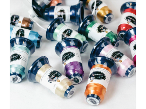 Assorted pastel spools of Embellish Flawless 60wt polyester thread are scattered.