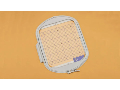 An embroidery hoop with a grid template, measuring 9 1/2" x 9 1/2".