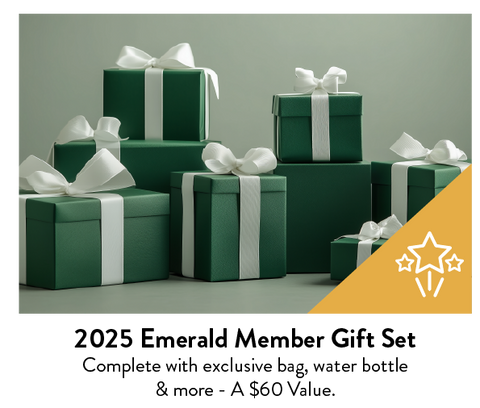 A collection of dark green gift boxes with white ribbons and bows.