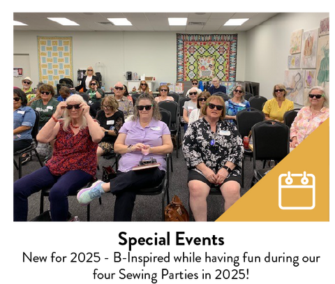 A group of people wearing sunglasses are seated in a room with quilts on the walls.