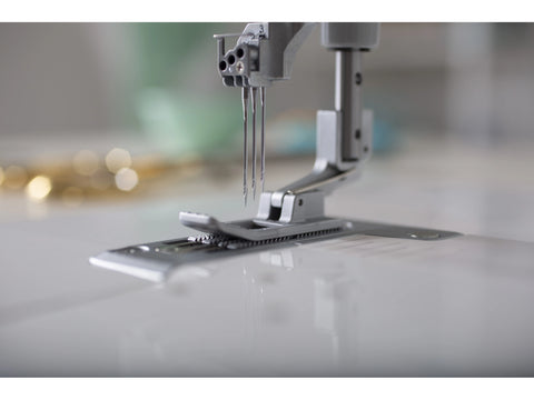 A close-up of a Baby Lock Euphoria cover stitch serger with three needles.